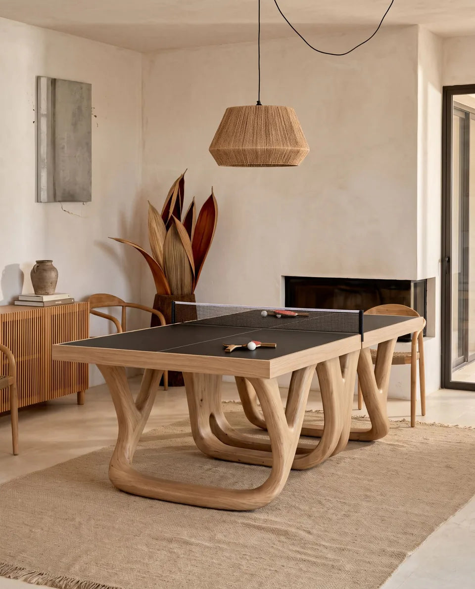 Table de ping-pong en bois clair aux pieds sculptés, suspension en corde et plante séchée