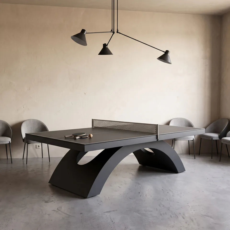 Table de ping-pong noire à piètement en arche, sous une suspension à trois bras, murs de chaux